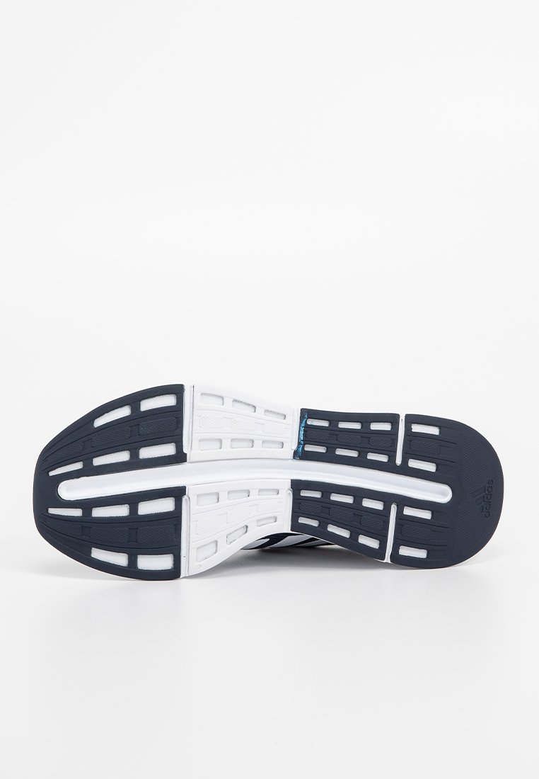 Schwarz-weißer Sport-Schuhsohle mit gemusterten Rillen und Ausschnitten für Grip, mit einer glatten, gummiartigen Textur.