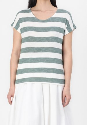 T-shirt rayé en tissu doux, avec des rayures horizontales vertes et blanches, un large col et des manches courtes. Associé à une jupe blanche.