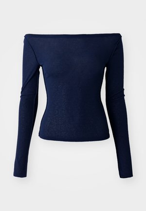 Mørkeblå langermet topp med off-the-shoulder design. Laget av et mykt, lett stoff som har en tettsittende silhuett.