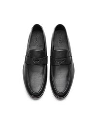 Mustad nahast loaferid sujuva tekstuuriga, ümmarguse varbaga ning dekoratiivse rihmaga ülevalt. Brändi nimi on sisetallal.