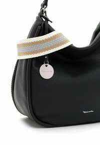 Sac à main en cuir noir à finition texturée, avec une bandoulière tressée beige, grise et blanche, et une étiquette logo argentée.