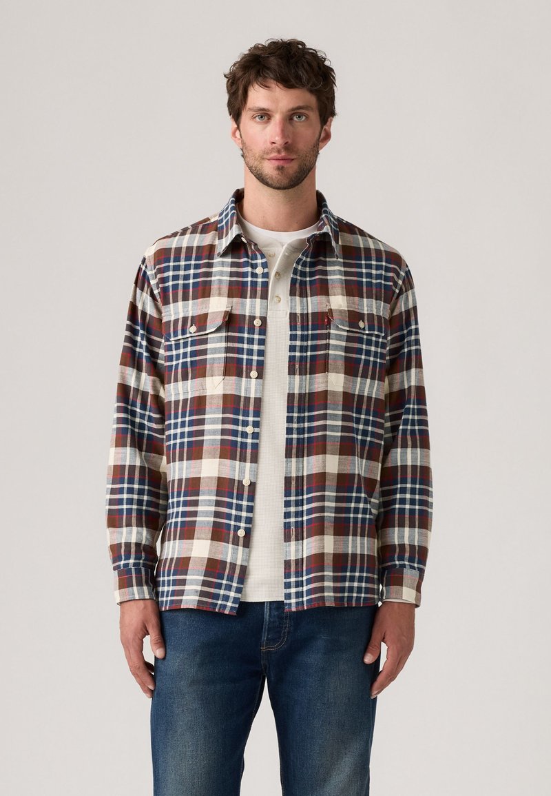 Geruite flanellen shirt in tinten blauw, rood en beige; twee borstzakken; knoopsluiting; middelzware stof; casual pasvorm.