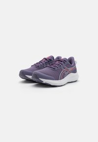 Chaussures de sport violettes avec une tige en maille, semelle blanche, embout renforcé et accents rouges contrastants sur le côté et les lacets. Conception légère et respirante.