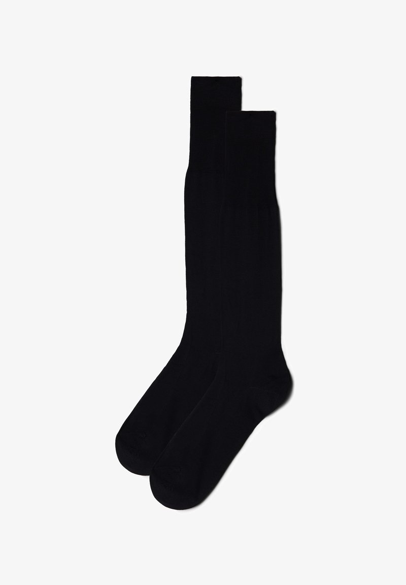 Czarne skarpetki do kolan wykonane z gładkiego materiału, z prążkowanym wzorem u góry i bezszwami w okolicy palców.