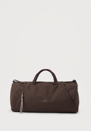 Donkerbruine Adidas duffeltas met dubbele handvatten, hoofdvak met rits en voorvak met rits en gevlochten ritskoorden.