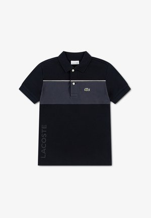 Zwart-grijs poloshirt met een tweekleurig ontwerp, voorzien van een kraag, knopen en een groen logo. Tekst "LACOSTE" in grijs aan de zijkant.