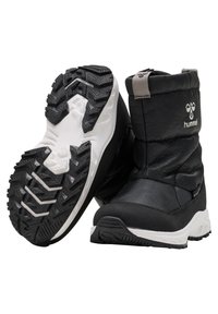 Svart isolerade stövlar med en texturerad gummisula och vita detaljer; har en mjukt vadderad ovandel och "hummel"-logotyp på sidan.