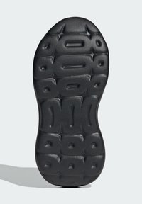 Schwarze Gummisohle mit einer strukturierten Oberfläche, die erhöhte sechseckige Muster und tiefe Rillen für besseren Halt und Flexibilität aufweist.