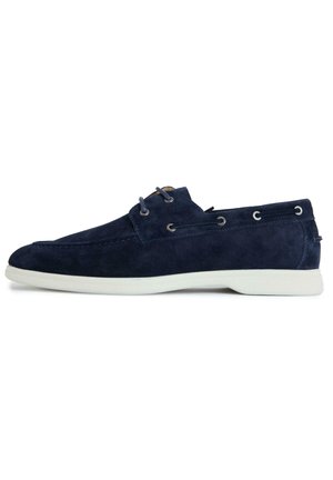 Navy blue suede boat shoe with white sole, lace-up front, and side eyelets on white background.