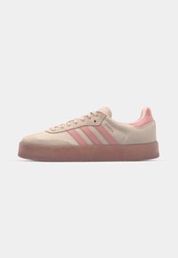 Beige Wildlederschuhe mit hellrosa Akzenten, strukturierter Gummisohle und drei rosa Streifen an der Seite. Runde Zehenform und Schnürdesign.