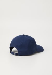 Marineblå baseball cap laget av bomull med en buet skygge, justerbar stropp bak, og en liten preget detalj som leser "ETABLERT 1922."