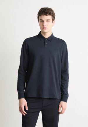 Polo cu mânecă lungă de culoare bleumarin, fabricat din bumbac. Dispune de o închidere cu nasturi și un logo brodat pe piept. Textură netedă și croială ajustată.