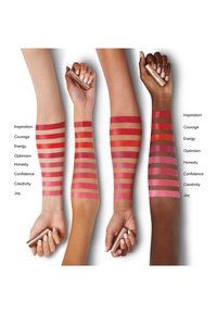 Four arms display various lip color swatches in red and pink shades. A hand holds a tube, with labels on the left for each shade.