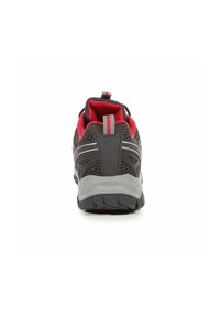 Dark gray and red athletic shoe viewed from the back with mesh upper, pull tab, and thick textured sole.