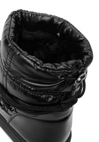 Czarna izolowana botka o błyszczącym wykończeniu, z marszczonym czubkiem i miękką czarną podszewką. Zawiera regulowany sznurek i szczegółowe przeszycia.