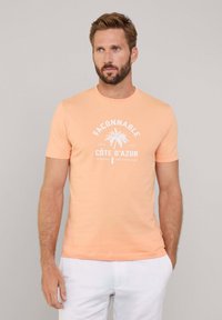Camiseta de algodón color naranja claro con un gráfico de palmera blanca y el texto "Façonnable Côte D’Azur" en un diseño circular. Mangas cortas.