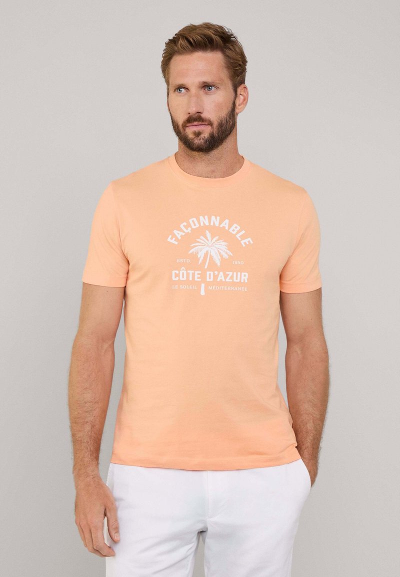 Camiseta de algodón color naranja claro con un gráfico de palmera blanca y el texto "Façonnable Côte D’Azur" en un diseño circular. Mangas cortas.