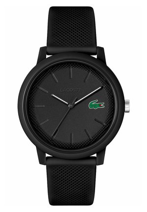 Black Lacoste watch featuring a textured dial, silver hands, and logo accent. Soft, patterned silicone strap. Minimalist design.