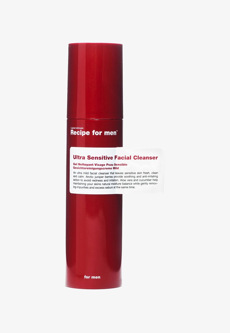 Bottiglia cilindrica rossa con finitura lucida, etichettata "Detergente Viso Ultra Sensibile", con testo bianco. Il design del tappo completa la forma elegante.