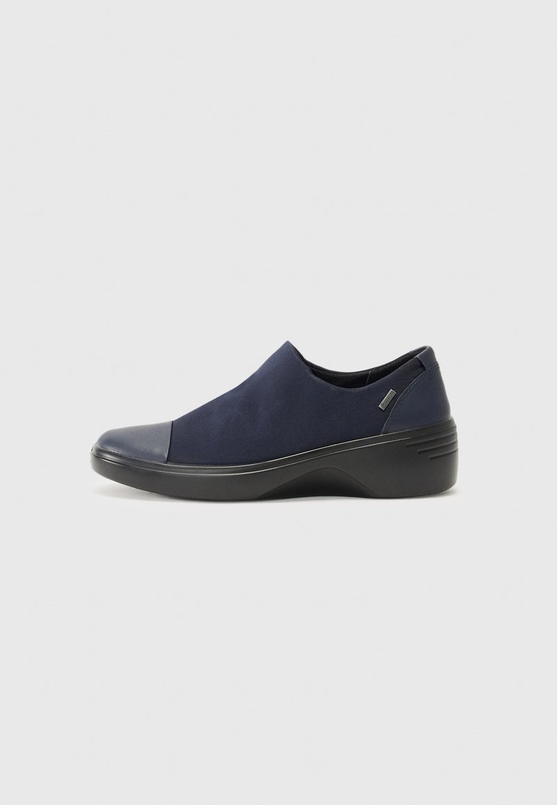 Marinhöga slip-on skor med ovandel i mocka och glansig svart tåspets. Har en strukturerad gummisula och vadderad häl för stöd.