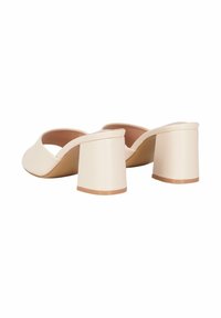 Mule beige con tacco a blocco, design aperto sulla punta, superiore in materiale sintetico liscio, linee curve e un tacco robusto e testurizzato.