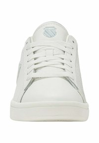 Baskets blanches avec un dessus en cuir lisse, des accents texturés, un bout rond et un patch logo sur la languette. Elles possèdent des lacets plats et une semelle en caoutchouc.