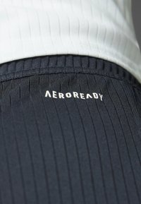 Dark navy athletic shorts with ribbed texture. Features a white "AEROREADY" logo on the front, complemented by a light gray top.