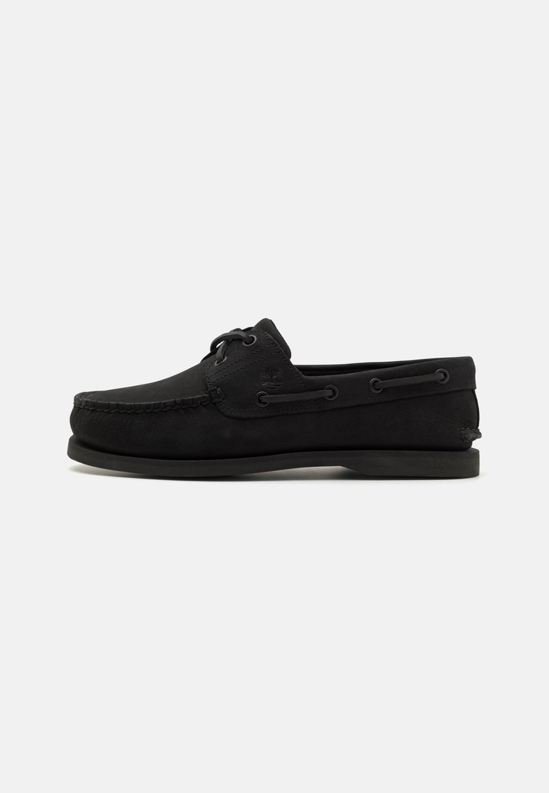 Mustad suede paadisaapad, millel on mokassini varvas, nahkpaelad ja metallist silmad. Tasane kummist tald ning delikaatne logo detail küljel.