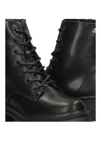 Botas de tobillo de cuero negro con diseño de cordones, puntera redondeada y suela de plataforma gruesa con acentos texturizados.