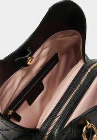 Sac à main en cuir noir avec texture embossée, quincaillerie en or rose, doublure en satin rose et poche zippée intérieure.