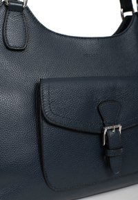 Borsa a tracolla in pelle blu navy con superficie texturizzata, caratterizzata da una tasca frontale con patta e un dettaglio in metallo argentato. Inclusa una tracolla regolabile.