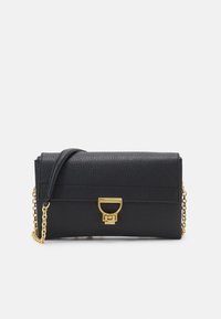 Sac à main en cuir noir avec une finition texturée, quincaillerie dorée et une chaîne en bandoulière. Dispose d'une fermeture à rabat avec un fermoir distinctif.