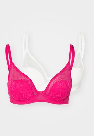 Sett med to bh-er: en rosa med blondedeksel og tynne stropper, den andre ensfarget hvit med glatt tekstur og justerbare stropper.