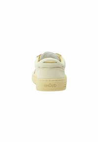 Sneaker di pelle bianca con finitura liscia, dotata di una suola in gomma beige, forma arrotondata e un piccolo logo sul tallone.