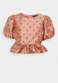 Persikofärgad satinblus med puffärmar och blommönster i blått och vitt. Har en rund halsringning och en volangfåll.