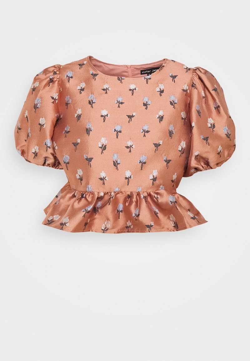 Persikofärgad satinblus med puffärmar och blommönster i blått och vitt. Har en rund halsringning och en volangfåll.