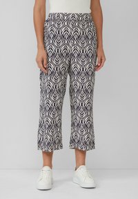 Wydrukowane, krótkie spodnie cechują się wzorem w liście w kolorze granatowym i kremowym, elastycznym pasem oraz lekkim materiałem. W połączeniu z białymi sneakersami.