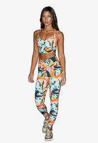 Färgglad sport-bh och leggings-set med abstrakta mönster i rosa, orange, grönt och blått. Mjukt material med en åtsittande design.