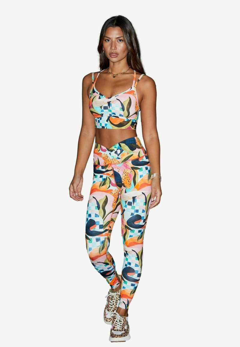 Färgglad sport-bh och leggings-set med abstrakta mönster i rosa, orange, grönt och blått. Mjukt material med en åtsittande design.
