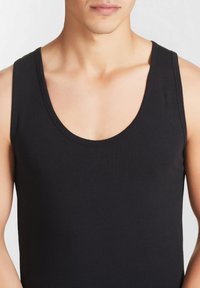 Canotte senza maniche nera in tessuto di cotone, con scollatura rotonda e design aderente per una silhouette attillata.