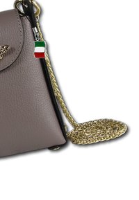Helle taupe Farbtasche aus Leder mit goldener Kettenriemen, die eine dekorative Schmetterlingshardware und ein kleines italienisches Flaggen-Detail aufweist.