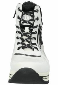Bottine noire et blanche avec une surface texturée, des lacets contrastants, fermeture éclair, et une doublure intérieure rembourrée avec une semelle en caoutchouc.