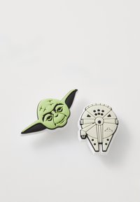 Yoda ja Millennium Falcon -pinssejä. Yoda on vihreä mustilla aksentteilla; Falcon on valkoinen harmailla yksityiskohdilla ja erottuvalla muotoilulla.