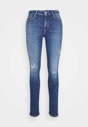 Blue skinny jeans with slight distressed details on thighs and knees, five-pocket style, button and zipper closure.