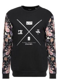 Sweat-shirt noir avec manches à motif floral, avec des graphiques blancs d'outils de couture et le texte "HAND CRAFTED SEAMSTRESS" sur le devant.