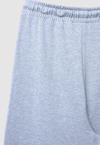 Pantaloni della tuta grigio chiaro con ampia cintura elastica, morbido al tatto e vestibilità rilassata, completi di tasche laterali.