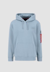 Svijetloplava kapuljača izrađena od mekanog materijala, s kengur džepom, kapuljačom s vezicom i crvenom etiketom s tekstom na lijevom rukavu.