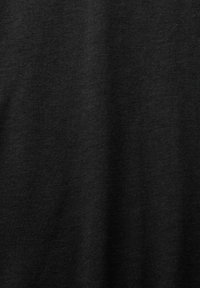 Svart bomullstyg med en slät textur, som visar fina stickningsmönster. Jämn färgfördelning, lämplig för olika klädesstilar.