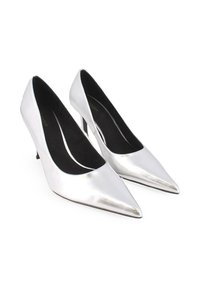Tacones altos de charol plateado con punta afilada, un diseño de corte bajo y un delgado tacón de aguja. Forro interior negro.
