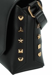 Borsa a tracolla nera in pelle con hardware dorato, caratterizzata da borchie decorative a forma di cuore, stella e geometrica lungo un lato.